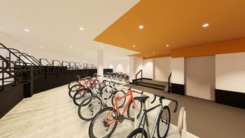 a row of bikes parked in a room with a staircase